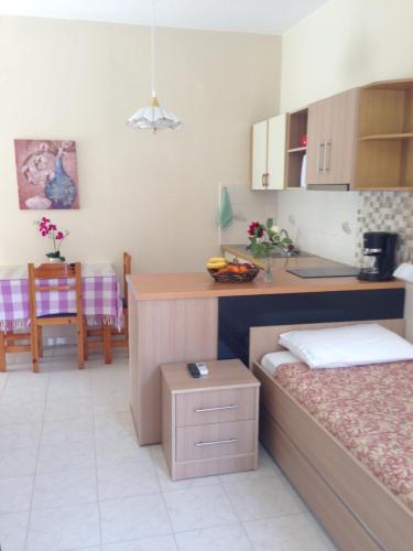a room with two beds and a kitchen with a table at Palmira Apartments in Makry Gialos