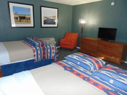 a hotel room with two beds and a tv and a chair at Bryce Canyon Resort in Bryce Canyon