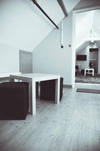 a living room with a white table and a tv at Hôtel La Poterne du Roy in Rocroi