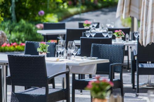 a row of tables and chairs with wine glasses at Tertianum Residenza Al Parco Appartements & Restaurant in Locarno