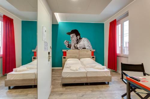a room with two beds and a painting on the wall at MEININGER Roma Termini in Rome
