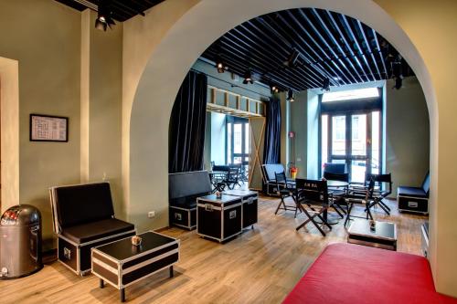 a living room with an archway with chairs and tables at MEININGER Roma Termini in Rome