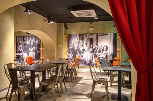 a restaurant with tables and chairs and a red curtain at MEININGER Roma Termini in Rome