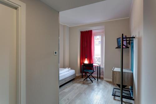 a bedroom with a bed and a desk and a window at MEININGER Roma Termini in Rome