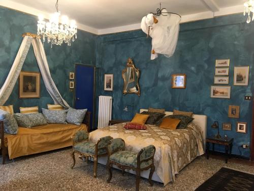 a bedroom with blue walls and a bed and a couch at La Chambre D'Ella in Venice