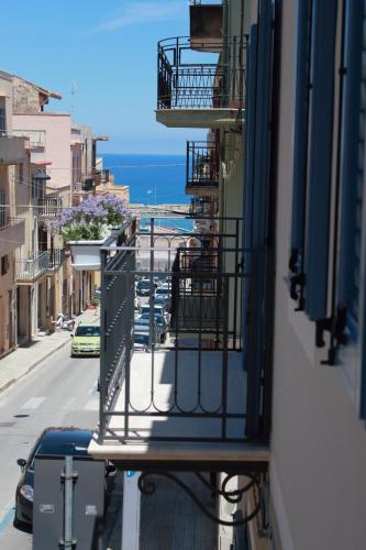 a balcony of a building with a view of the ocean at Calida B&B in Castellammare del Golfo