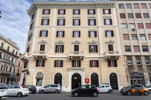 a large building with cars parked in front of it at MEININGER Roma Termini in Rome