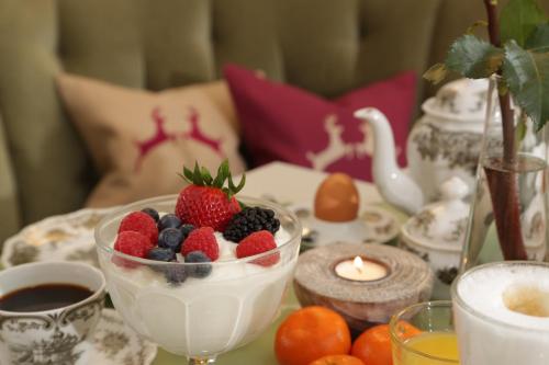 a table topped with a bowl of fruit and a candle at Landhaus Ertle in Bad Wiessee