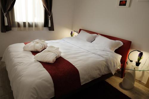 a bedroom with a large bed with white sheets and pillows at Dominus Residence in Cluj-Napoca