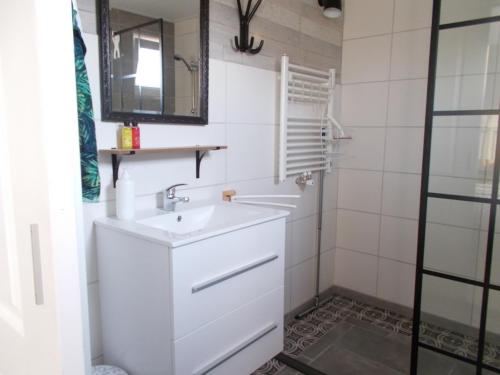 a white bathroom with a sink and a mirror at Middenpaed in Balk