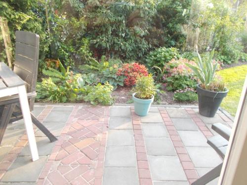 a patio with potted plants and a table and bench at Middenpaed in Balk