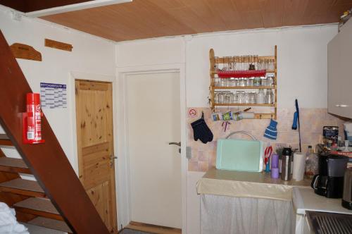 a small kitchen with a counter and a door at Bed & Breakfast, Oqaatsut/Rodebay in Oqaatsut