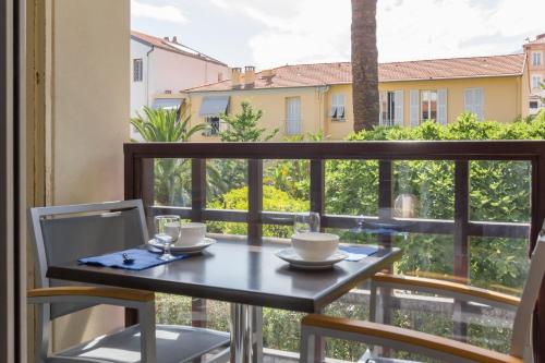 una mesa y sillas en un balcón con vistas en Résidence Pierre & Vacances Les Citronniers, en Menton