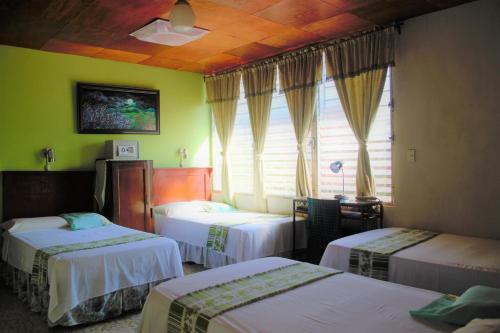 a hotel room with three beds and a window at Hotel Oasis in San Salvador