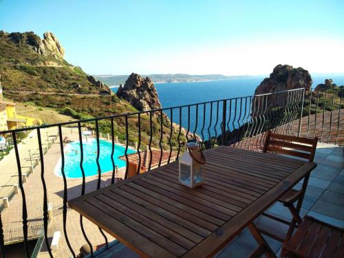 a wooden bench sitting on a balcony next to a pool at Il Blu Tanca Piras in Nebida