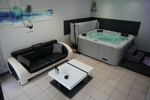 een woonkamer met een hot tub en een bank bij Appart&Spa in Toulouse