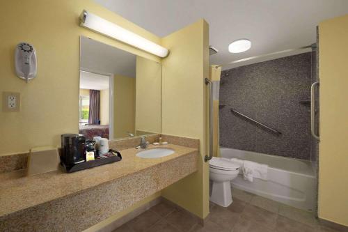 La salle de bains est pourvue d'un lavabo et de toilettes. dans l'établissement Rose Garden Inn & Suites Thomasville, à Thomasville