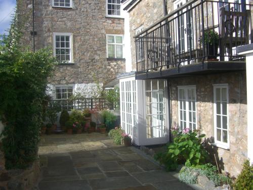 a courtyard in front of a stone building with a balcony at Hannaford's Quay, 11 The Strand in Exeter