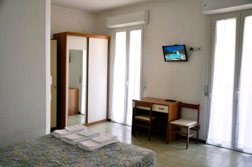 カットーリカにあるAlbergo Larenziaのベッドルーム1室(ベッド1台、デスク、窓付)