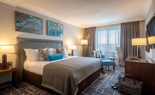 ein Hotelzimmer mit einem großen Bett und einem Schreibtisch in der Unterkunft The Killeshin Hotel Portlaoise in Portlaoise