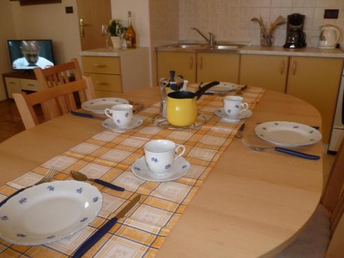 a table with plates and cups on it in a kitchen at Appartamento Camelia in Fažana