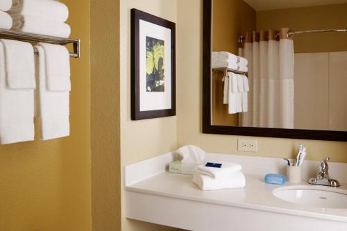 a bathroom with a sink and a mirror and towels at Extended Stay America Suites - St Louis - St Peters in Saint Peters
