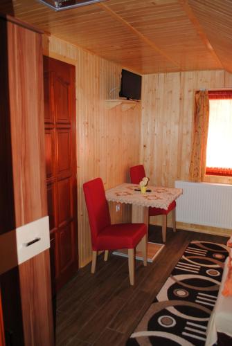 a room with a table and two chairs and a television at Rózsapark Vendégház in Demjén