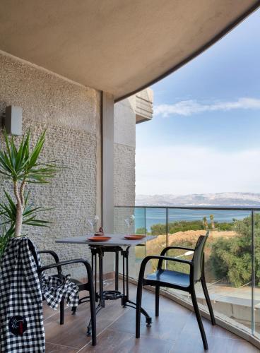 a patio with a table and chairs and a view of the ocean at Şato Design Hotel in Cesme