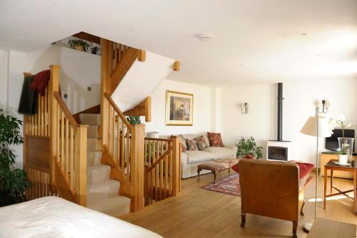 a living room with a staircase and a couch at Hannaford's Quay, 11 The Strand in Exeter