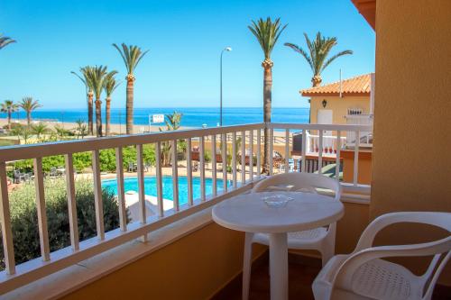 a balcony with a table and a view of the ocean at Hostal Esperanza in Benajarafe