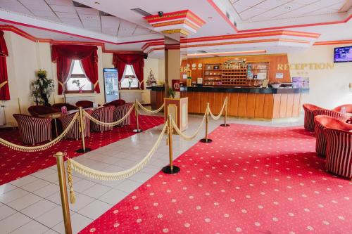 a banquet hall with red carpet and a red floor at Hotel Gloria Palac in Košice