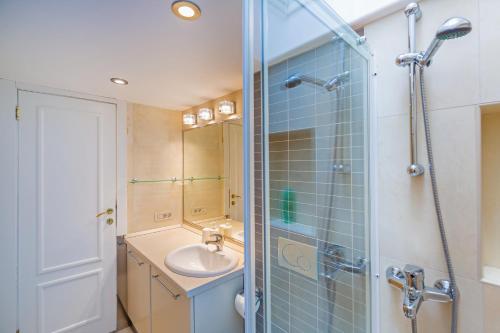 La salle de bains est pourvue d'un lavabo et d'une douche en verre. dans l'établissement Apartment Bona Palace, à Dubrovnik