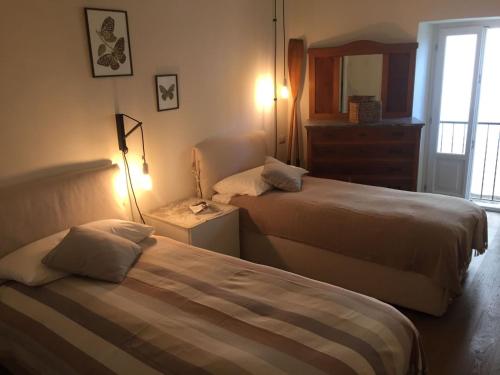 a hotel room with two beds and a window at Al vecchio porto casa a Cannero in Cannero Riviera