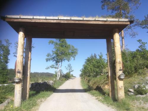 une route traversant une arche en bois sur un chemin de terre dans l'établissement Hagen, à Vennesla