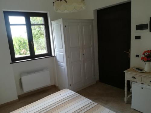 a room with a window and a door and a table at AGRITURISMO Masseria Spetterrata in Cisternino