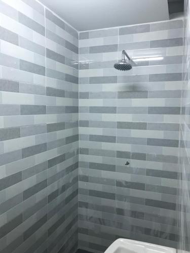 a bathroom with a shower with gray tiles at Cempaka Homestay Batu Pahat in Batu Pahat