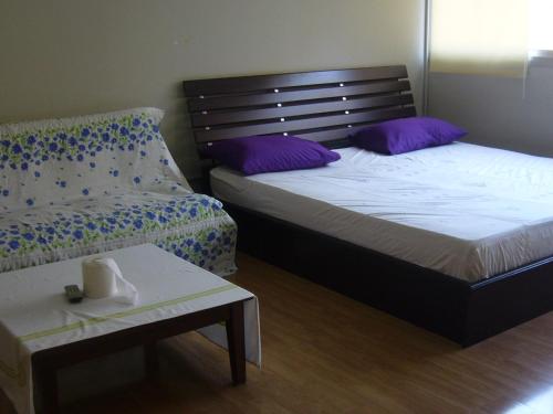 two beds in a room with purple pillows and a table at IMPACT Don Mueang Bangkok Guest House in Nonthaburi