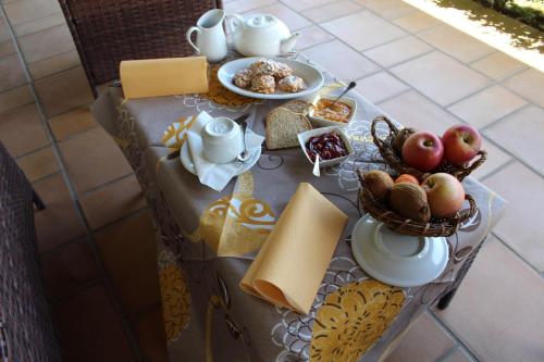 une table avec un service à thé, des pommes et du fromage dans l'établissement Agriturismo IL CASTAGNETO, à Padula