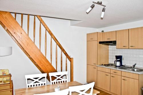 a kitchen with a dining room table and a staircase at Hof Kranichstein in Kluis