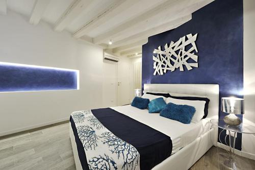 a bedroom with a blue and white bed with blue pillows at Ca Forner - Cannaregio Apartment in Venice