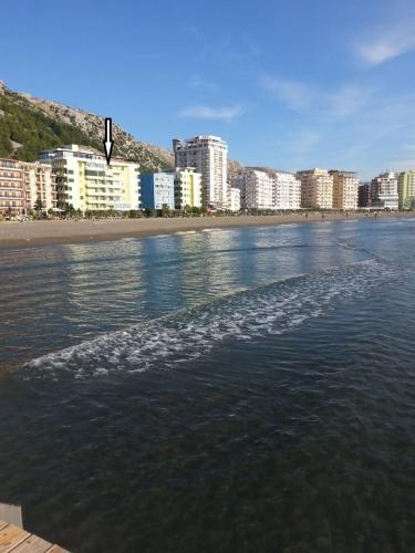 a body of water with a beach and buildings at Apartment Sea View in Shëngjin