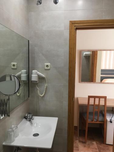 La salle de bains est pourvue d'un lavabo et d'un miroir. dans l'établissement Hostal San Martin, à San Martín de la Vega