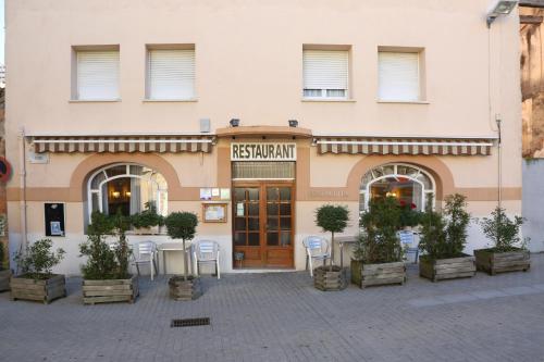 a restaurant with tables and chairs in front of a building at Fonda Rita in Sant Hilari Sacalm