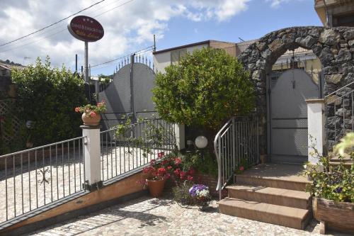 einen Eingang zu einem Haus mit einem Tor und Blumen in der Unterkunft B&B Villa Liliya in Fiumefreddo di Sicilia