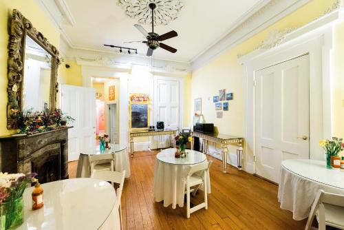 a room with tables and chairs and a fireplace at Creole Gardens Guesthouse and Inn in New Orleans