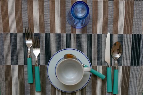 a table with a plate and a cup and fork and knife at Apartment Stella Maris in Capri