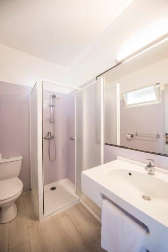 une salle de bain avec un lavabo, des toilettes et un miroir dans l'établissement ULVF Les Residences du Colombier, à Fréjus