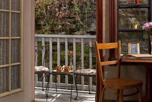 a porch with a table and chairs and a window at Cliff Cottage Inn, Downtown Bed & Breakfast in Eureka Springs