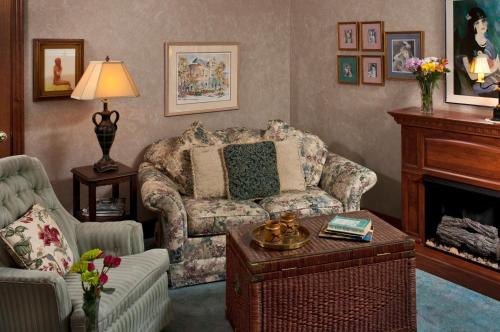 a living room with a couch and a fireplace at Cliff Cottage Inn, Downtown Bed & Breakfast in Eureka Springs