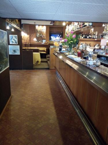 a restaurant with a bar and a dining room at Hotel Locanda Mel in Calolziocorte